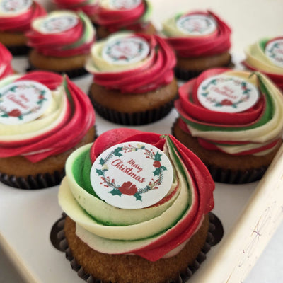 Christmas-themed cupcakes with colorful frosting and 'Merry Christmas' labels.